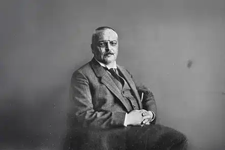 Un professionnel de la santé ou du bien-être discutant avec une femme préoccupée, dans un cadre lumineux et apaisant, avec un arrière-plan flou montrant une conversation entre deux autres personnes.