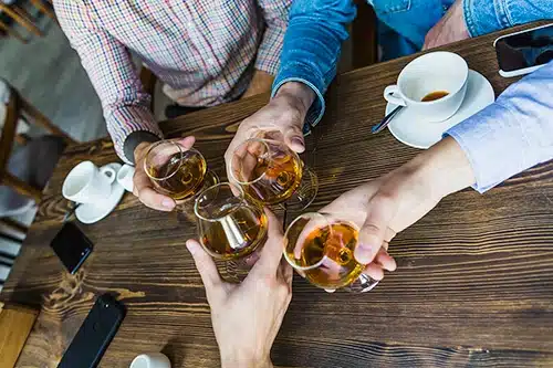 Un professionnel de la santé ou du bien-être discutant avec une femme préoccupée, dans un cadre lumineux et apaisant, avec un arrière-plan flou montrant une conversation entre deux autres personnes.