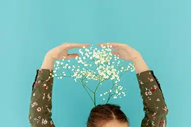 Un professionnel de la santé ou du bien-être discutant avec une femme préoccupée, dans un cadre lumineux et apaisant, avec un arrière-plan flou montrant une conversation entre deux autres personnes.