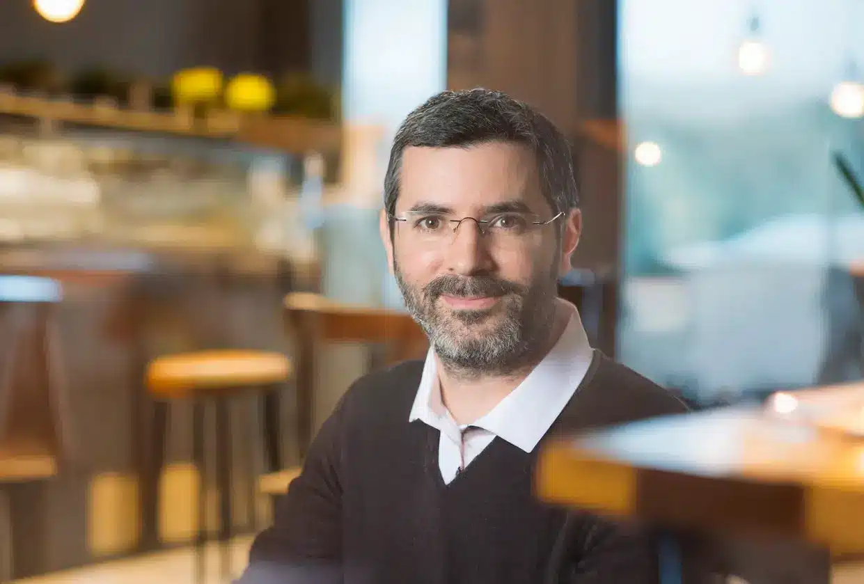 Portrait de Sébastien, consultant en prévention des risques professionnels, assis dans un café convivial