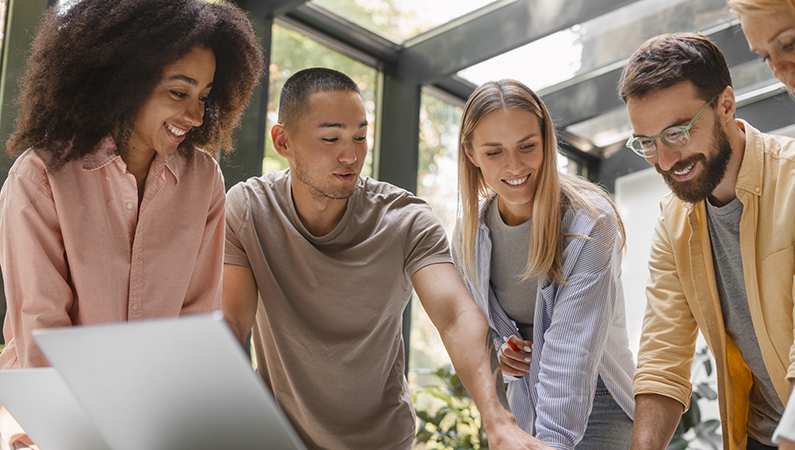 Groupe de professionnels échangeant avec enthousiasme autour d’une table lors d’une formation en management axée sur le leadership serein et collaboratif.