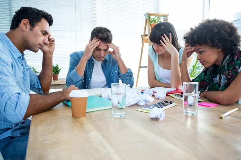 Équipe de travail sous pression illustrant le stress et la fatigue mentale en milieu professionnel