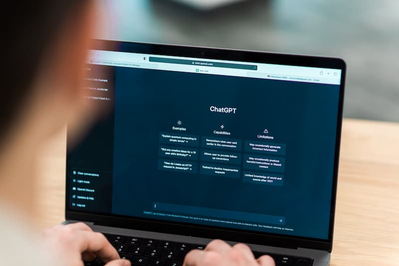 Personne utilisant un ordinateur portable avec interface d’intelligence artificielle au travail et analyse des risques professionnels.