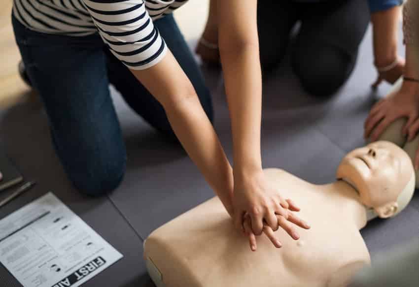 Participante pratiquant les compressions thoraciques sur mannequin lors d'une session de formation AFGSU 2.