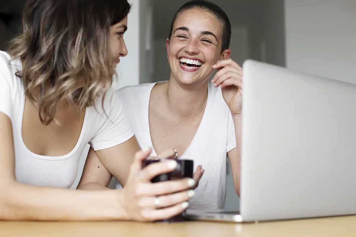 Un professionnel de la santé ou du bien-être discutant avec une femme préoccupée, dans un cadre lumineux et apaisant, avec un arrière-plan flou montrant une conversation entre deux autres personnes.