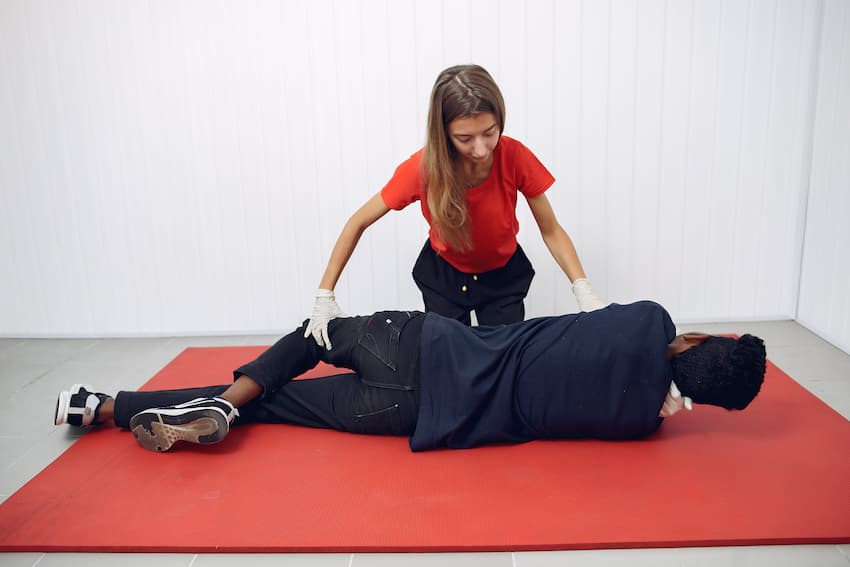 Professionnelle de santé pratiquant la mise en position latérale de sécurité sur une victime lors d'une formation AFGSU 2.