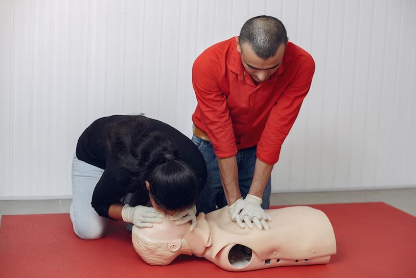 Deux participants en formation pratiquant les gestes de réanimation cardio-pulmonaire sur mannequin lors d'une session AFGSU 1.