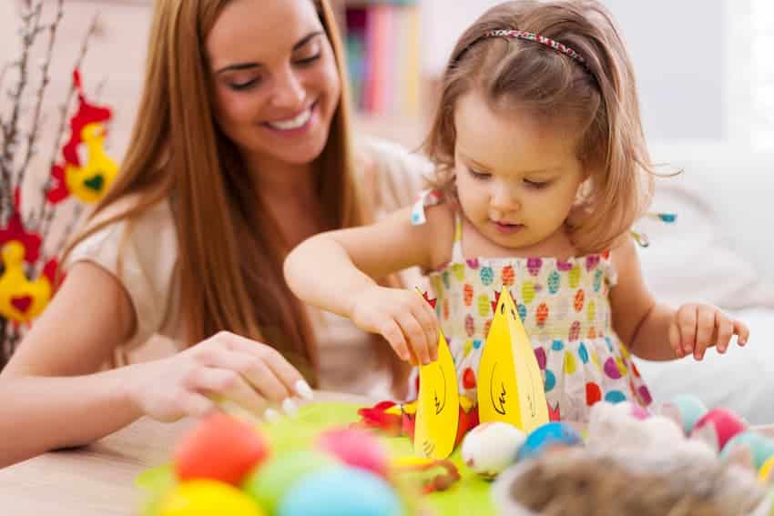 Professionnelle de la petite enfance accompagnant une jeune enfant lors d'une activité manuelle, illustrant les gestes du quotidien couverts par la formation PRAP Petite Enfance.