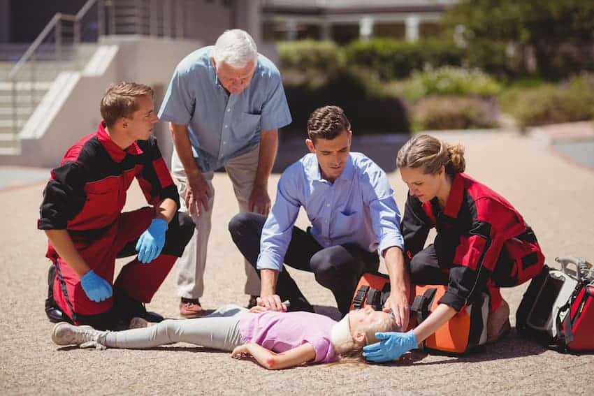Équipe de secouristes intervenant auprès d'une victime inconsciente lors d'une mise en situation de formation aux gestes d'urgence.