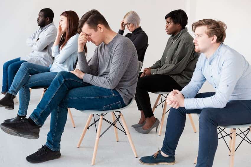 Groupe de salariés assis en cercle lors d'une session de sensibilisation aux risques psychosociaux en entreprise.