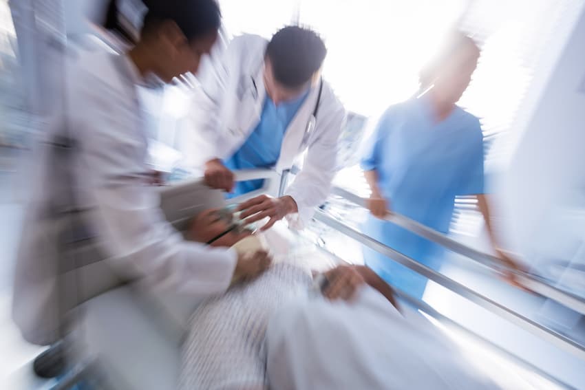 Équipe soignante intervenant en urgence auprès d'un patient lors d'une prise en charge médicale.