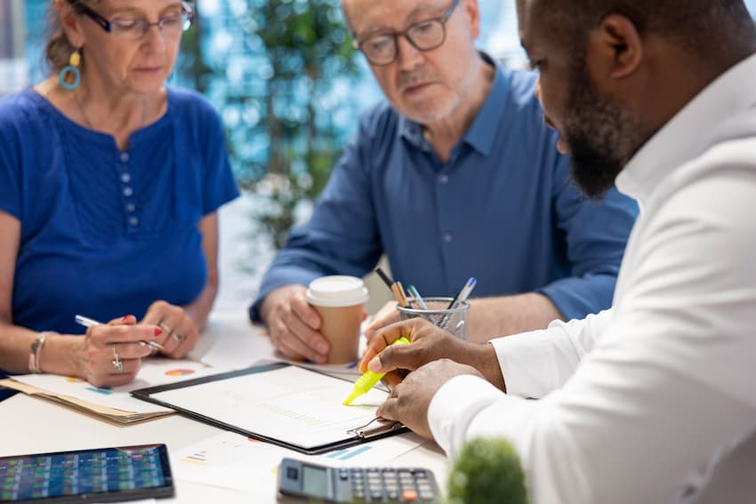 Élus CSE et formateur analysant des documents réglementaires, illustrant les obligations de formation des membres du Comité Social et Économique selon le Code du travail.
