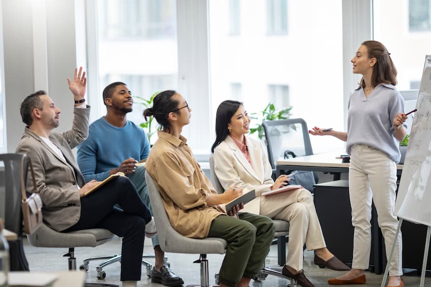 Groupe d'élus CSE en session de formation avec une formatrice devant un tableau blanc, illustrant l'organisation de la formation des membres du Comité Social et Économique en entreprise.