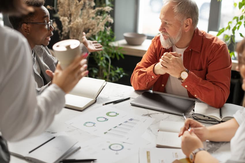 Membres d'un CSE en réunion autour d'une table avec des documents, illustrant le rôle et les missions du Comité Social et Économique en entreprise.