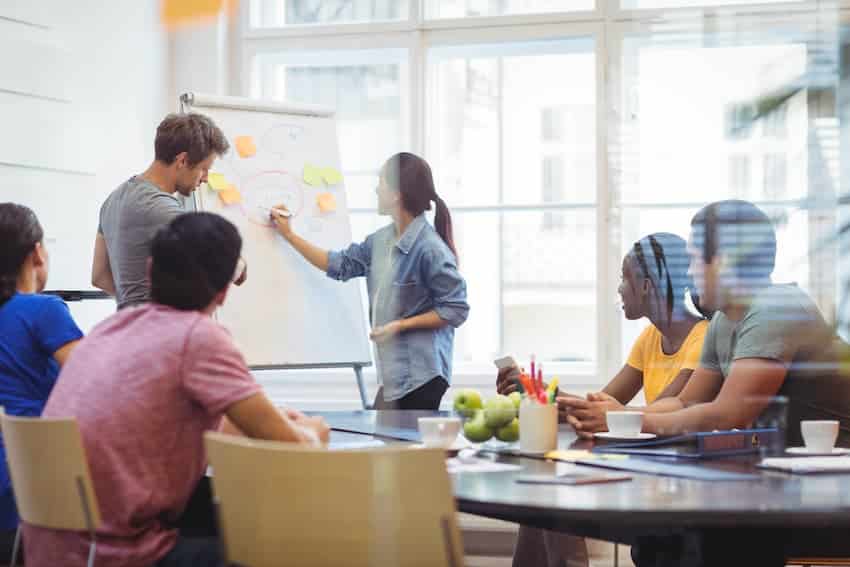 Homme et femme se faisant face avec des bulles de dialogue, symbolisant l'échange en entreprise.