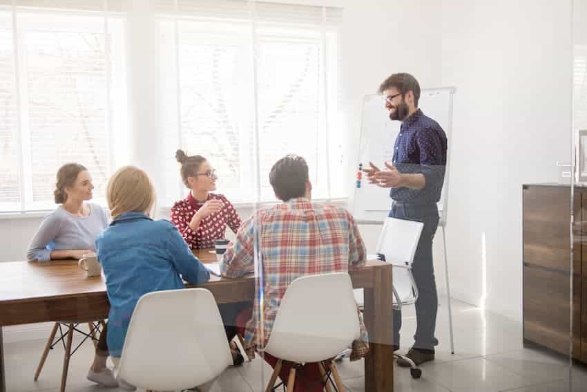 Formateur présentant devant un groupe de salariés en salle de réunion, illustrant une session de formation financée par un OPCO.